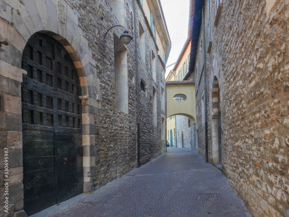   ncient medieval alley with stone buildings in the historic center of a small village in Lombardy