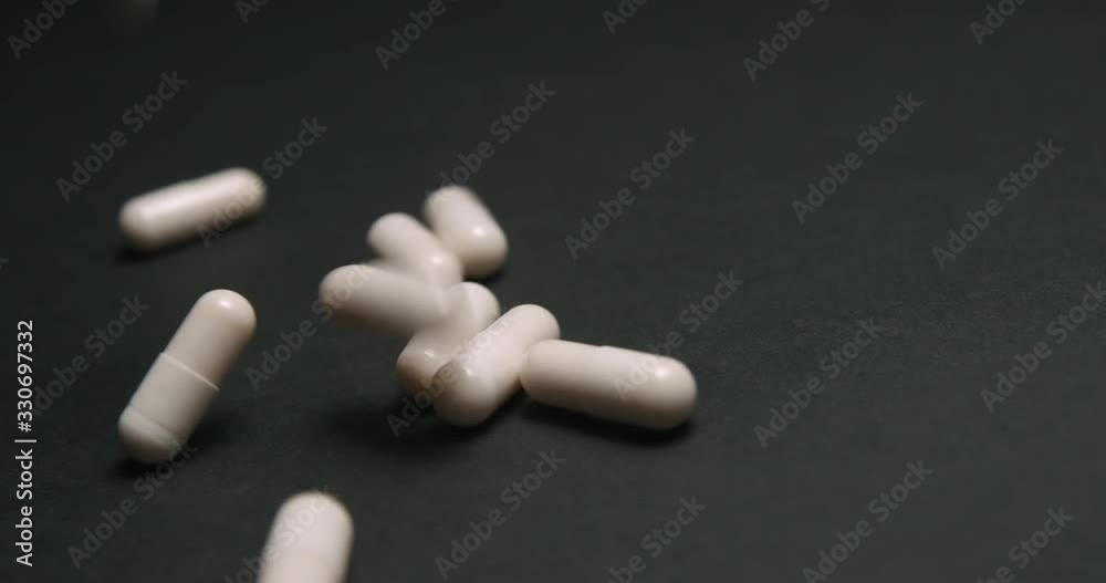 Pills medicine falling on black background close-up slow motion, studio shot in 4K prores HQ Pills medicine falling on black background close-up slow motion, studio shot in 4K prores HQ