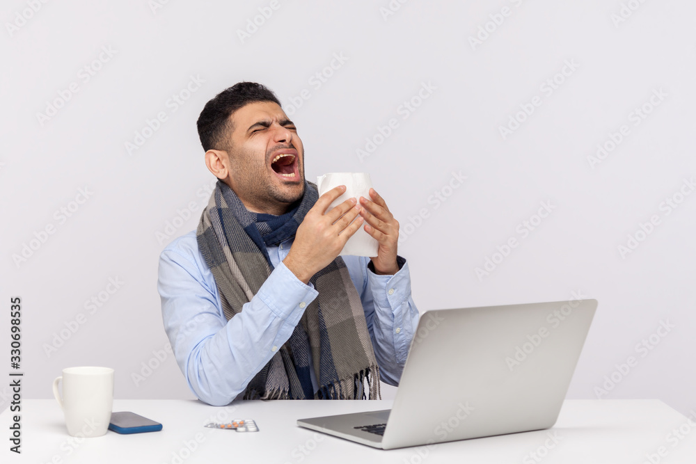 Flu-sick businessman sneezing in tissue, sitting in office feeling unwell, risk of coronavirus infection, contagious disease 2019-nCoV, influenza epidemic. studio shot isolated on white background Flu-sick businessman sneezing in tissue, sitting in office feeling unwell, risk of coronavirus infection, contagious disease 2019-nCoV, influenza epidemic. studio shot isolated on white background
