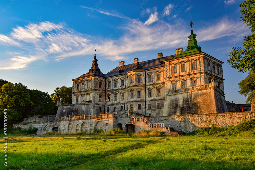 Fototapeta premium Stunning morning view of medieval Pidhirtsi Castle illuminated by rising sun, Pidhirtsi village, Lviv region, Ukraine