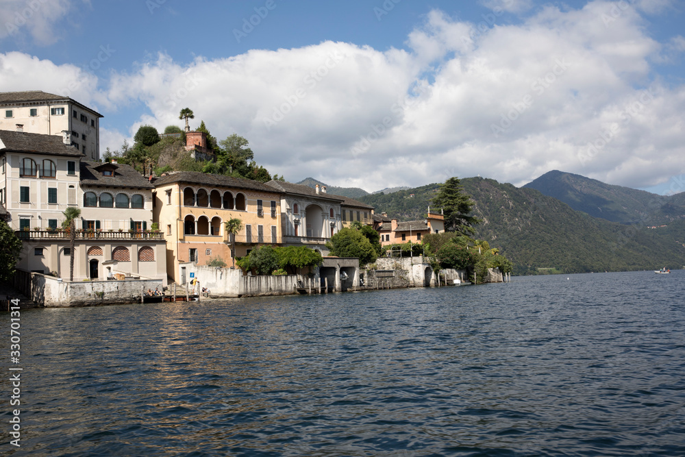 Orta San Giulio (NO), Italy - September 02, 2019: Houses view from the boat at Orta San Giulio island, Orta, Novara, Piedmont, Italy