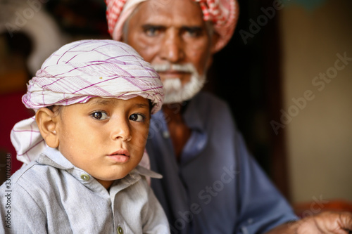 a depressed Arab grand father with his young cute grandson  
