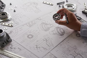 Engineer technician designing drawings mechanical parts engineering Engine.manufacturing factory Industry Industrial work project blueprints measuring bearings caliper tools