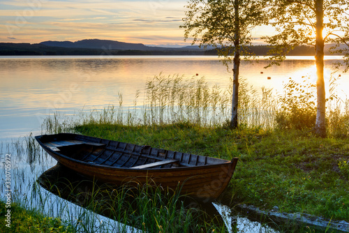 Boat at the lakeside at sunset, Solleron, Dalarna, Sweden photo