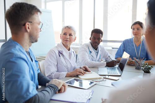 Fotografija Portrait of mature female doctor heading committee meeting at medical council, c
