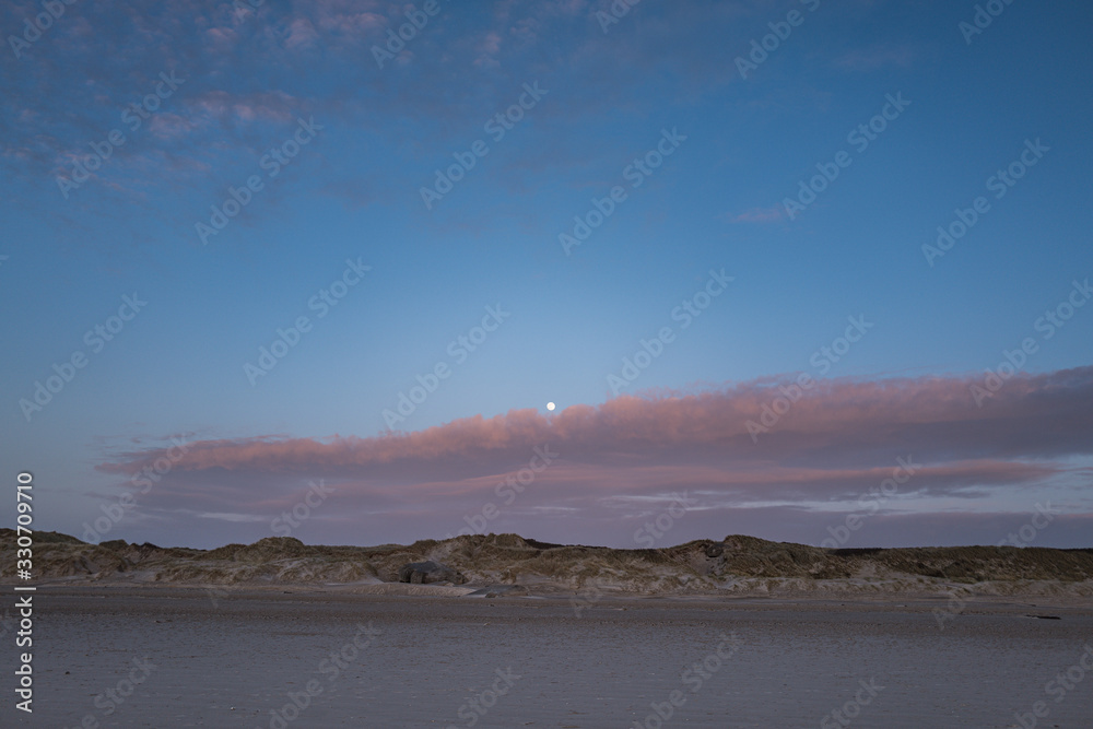 full moon rising over danish dunes