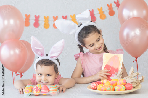 Children at the table decorated with balloons for Happy Easter.