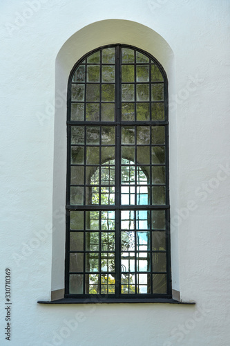 Tall vaulted window on a white stone wall