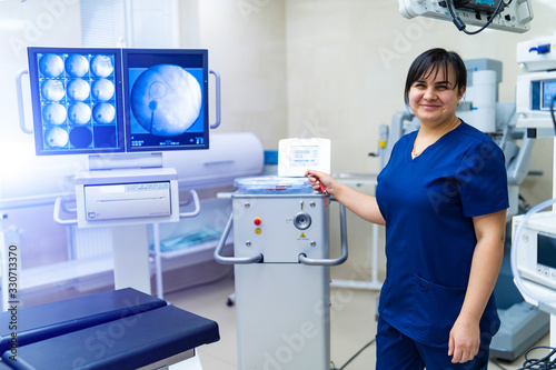 Smiling female doctor looking at camera on background with modern equipment.