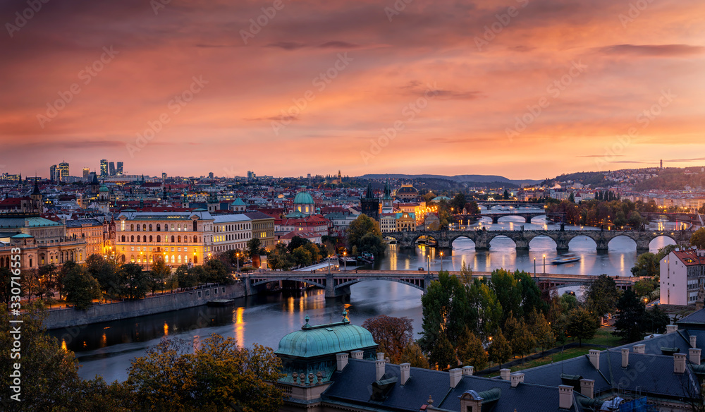 Panoramablick auf die Stadt Prag nach Sonnenuntergang mit der Moldau, Karlsbrücke, der Altstadt und den modernen Wolkenkratzern im Hintergrund