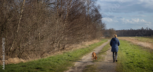 Walking the dog at National Park the Weerribben de Wieden Overijssel Nertherlands. De Wetering. Nederland. Peetlands and reedfields.