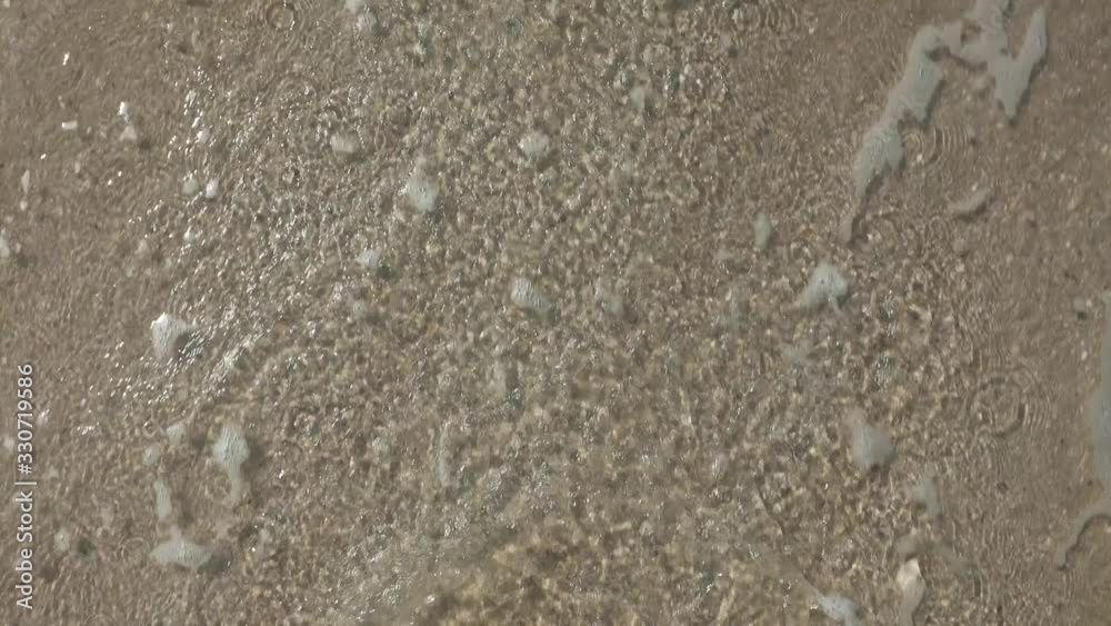 Feet of a caucasian man that walks out of the sea