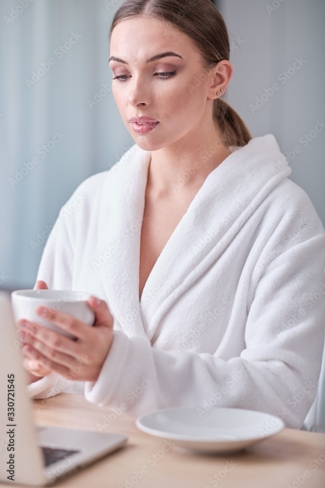 woman looking at laptop while at home in office work space . coronavirus epdemic. woman looking at laptop while at home in office work space . coronavirus epdemic.