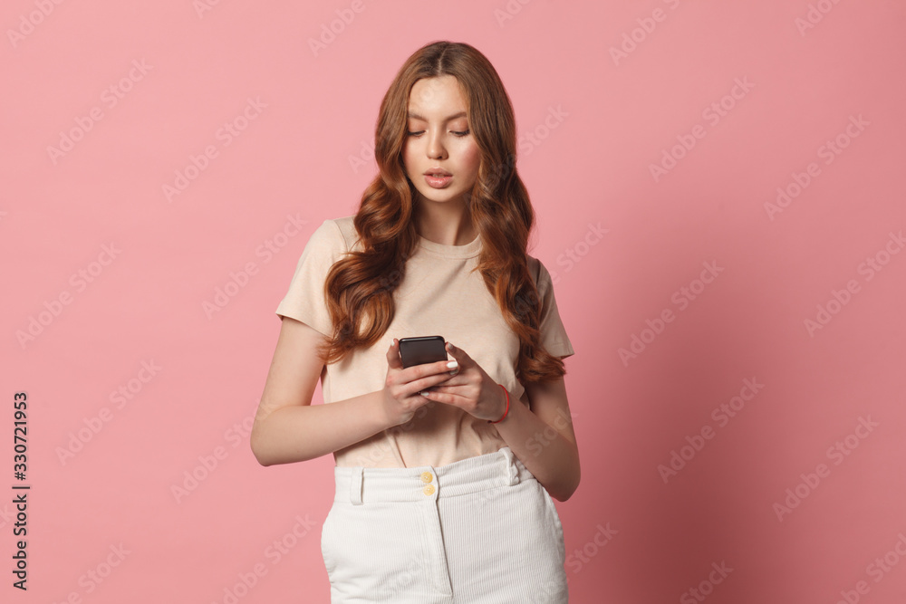 young beautiful woman using smart phone isolated on pink background young beautiful woman using smart phone isolated on pink background