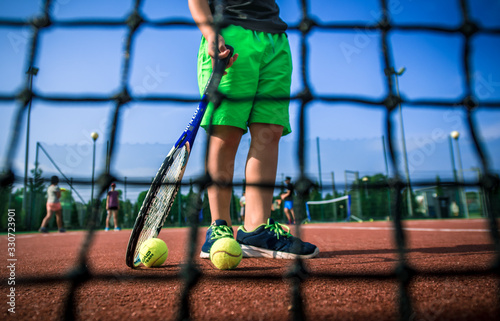 summer camp, Little tennis player on a blurred green background