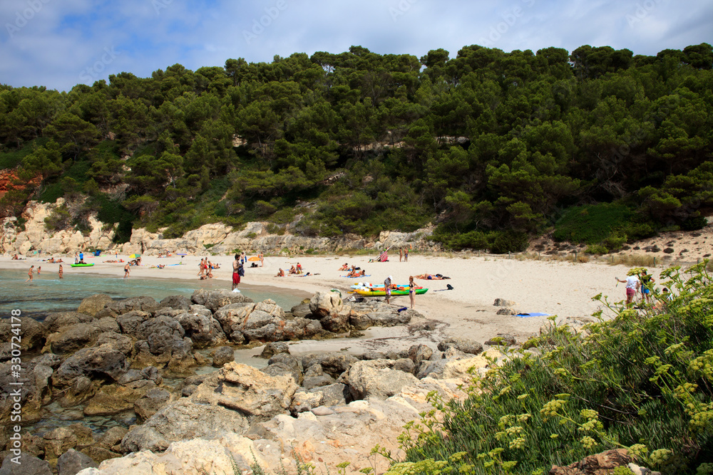 Fototapeta premium Es Migjorn Gran, Menorca / Spain - June 25, 2016: The Escorxada beach and bay, Es Migjorn Gran, Menorca, Balearic Islands, Spain