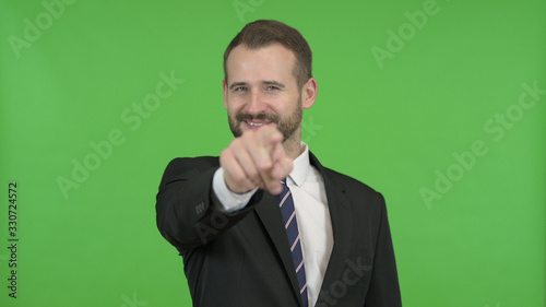 The Cheerful Businessman Pointing Finger and Inviting against Chroma Key