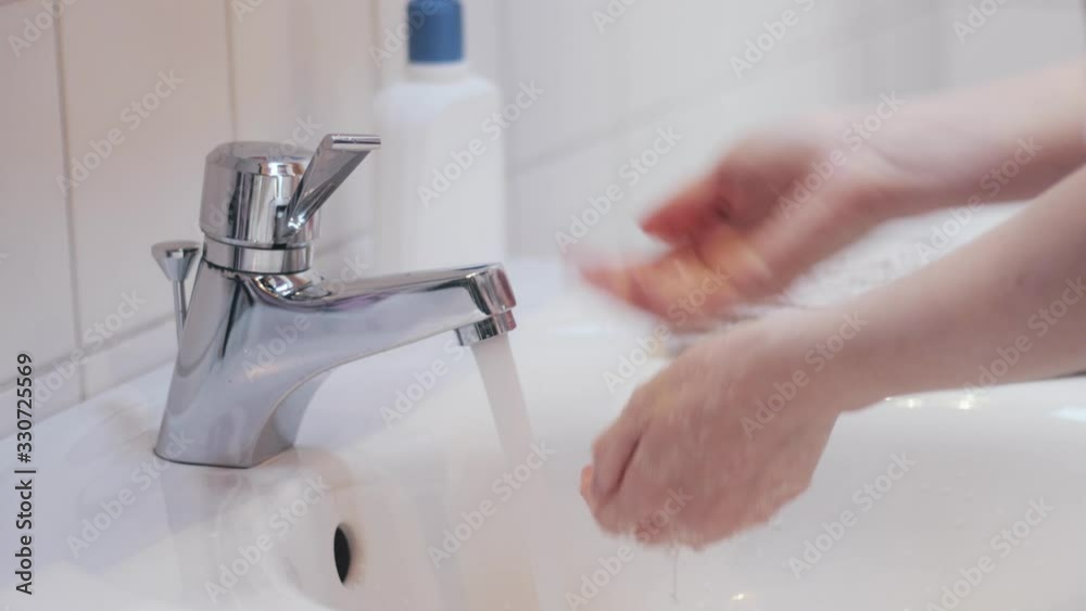 Washing hands with soap and water. Young woman using bathroom sink faucet and cleaning her hands. Hygiene, health, sanitation concept. Corona Virus Prevent Spreading and Epidemic Outbreak. 