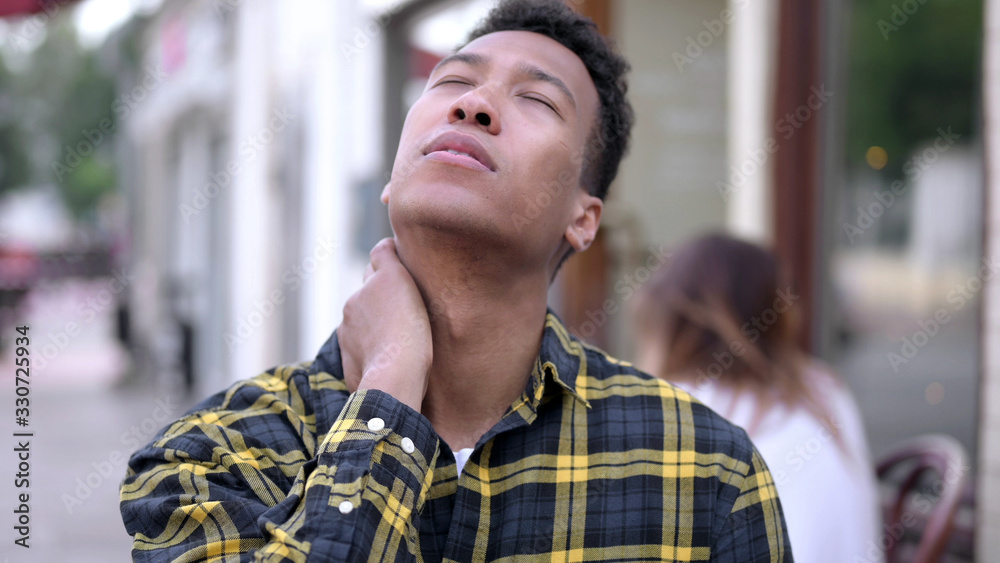 Obraz premium The Tired Young African Man with Neck Pain