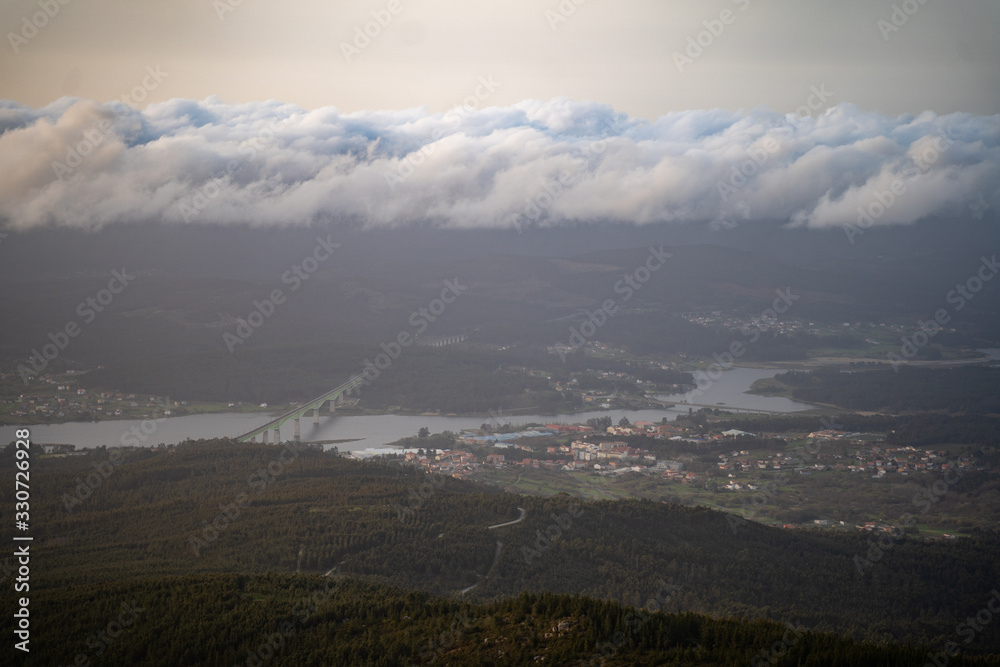 Aerial view of galician city with river and clouds at sunset