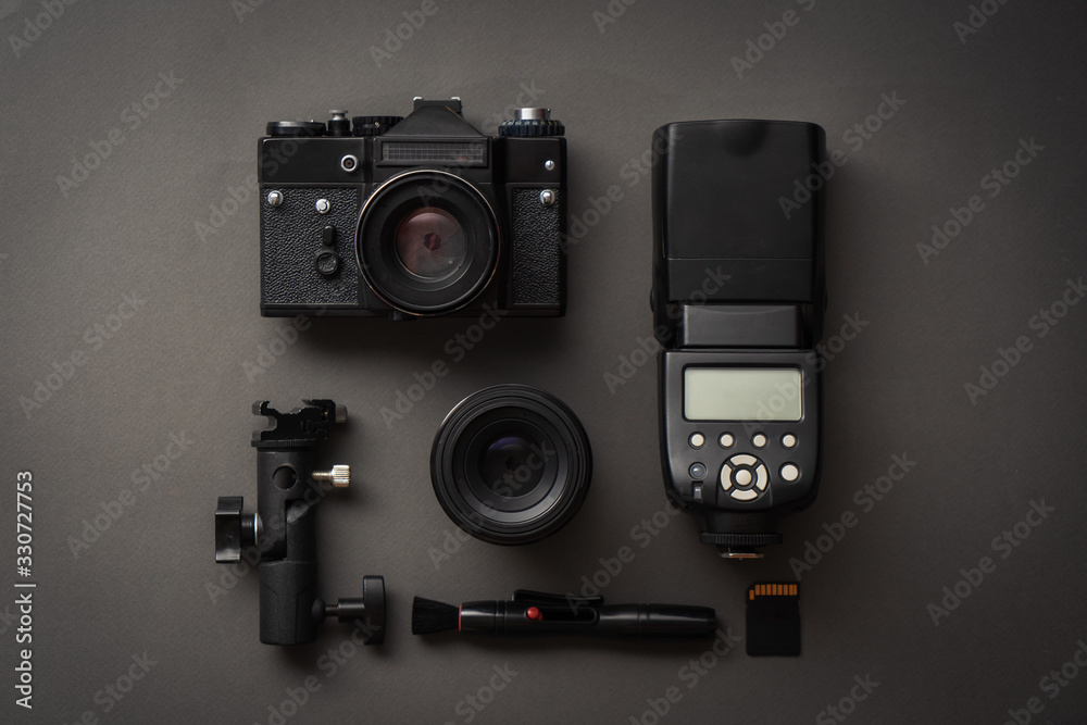Minimalistic black: view of the camera, flash, lens and cleaning tool. - obrazy, fototapety, plakaty 