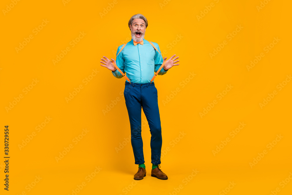 Fototapeta premium Pełnej długości zdjęcie fajnych modnych rąk dziadka rozciągliwe szelki charyzmatyczna osoba stylowy wygląd ubrania nosić koszulę muszkę spodnie buty skarpetki na białym tle żółty kolor tła