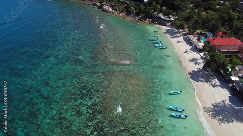 Aerial Thailand: koh Phangan island, Haad Rin beach line, taxi boats area, Static(still)lock down shot  photo
