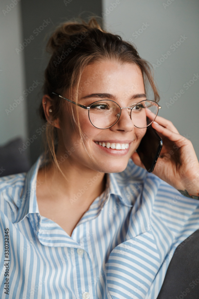Smiling young businesswoman talking on mobile phone