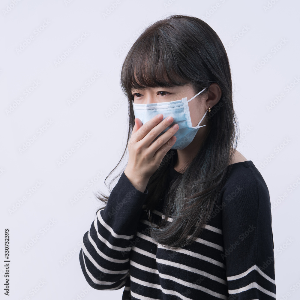 Woman coughing with face mask - young Asian covering the mouth by hand, feeling unwell illness isolated on white background, close up, copy space Woman coughing with face mask - young Asian covering the mouth by hand, feeling unwell illness isolated on white background, close up, copy space