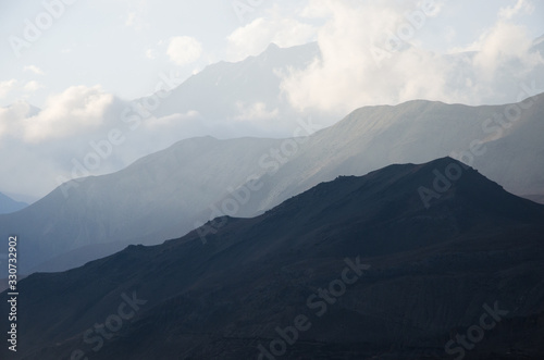 Montañas de diferentes alturas y colores con nubes en el Himalaya  photo