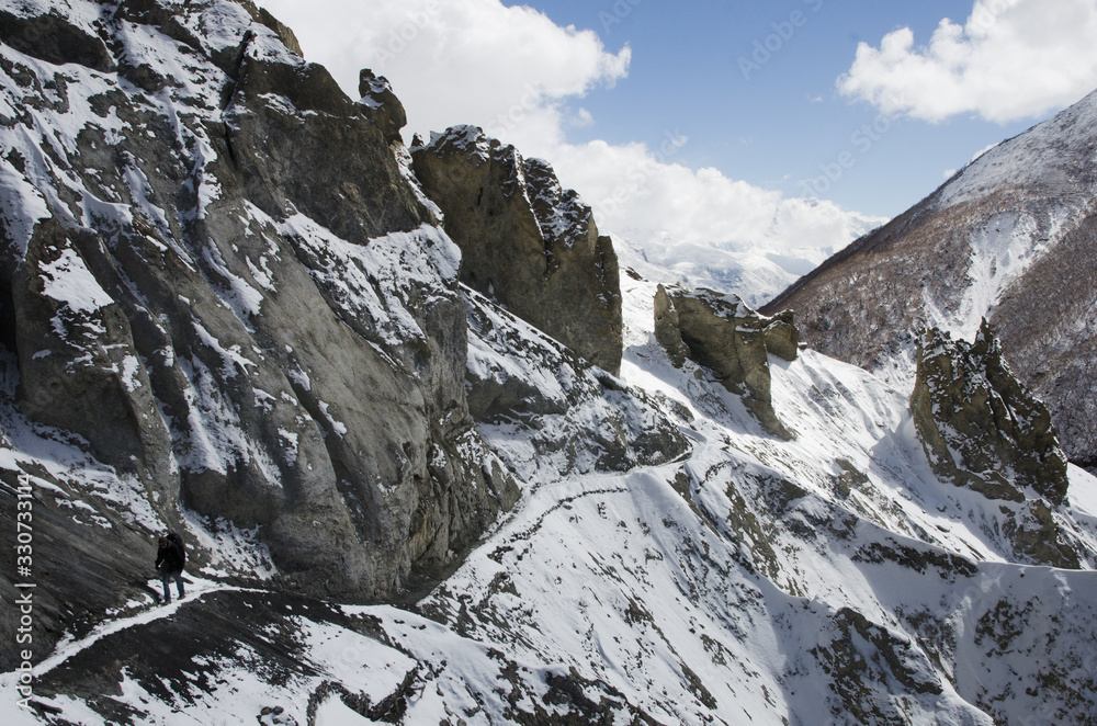 Senderista solitario caminando por un paisaje montañoso nevado en el Himalaya