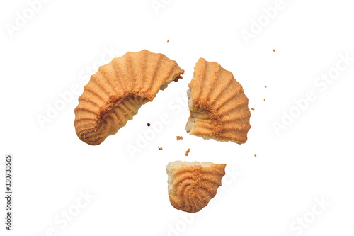 A yellow cookie broken into several pieces with crumbs around. Top viev, isolated