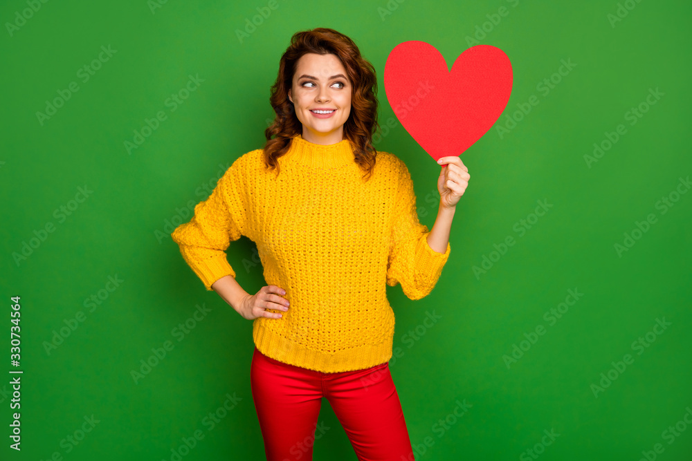 Photo of pretty charming wavy lady hold paper heart shape postcard romance date invitation think of answer wear yellow knitted sweater red pants isolated bright green color background Photo of pretty charming wavy lady hold paper heart shape postcard romance date invitation think of answer wear yellow knitted sweater red pants isolated bright green color background