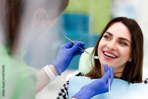Smiling woman at the dentist s appointment. beautiful positive girl at a routine examination at the dentist