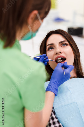 Dentist does an oral examination. Pretty patient woman came to the dentist s appointment