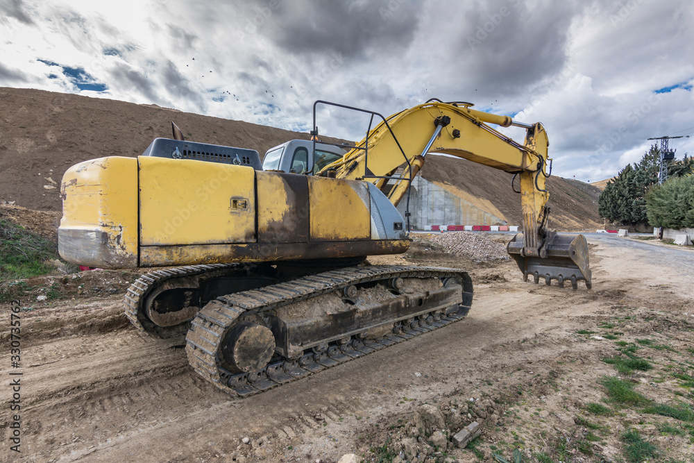 An excavator extracting dirt in a construction site An excavator extracting dirt in a construction site