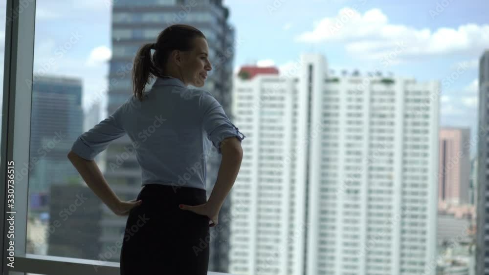 Young happy businesswoman admire view from window at office Young happy businesswoman admire view from window at office