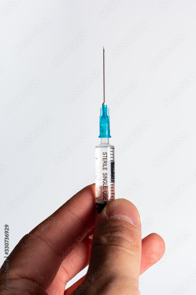 Hands holding a syringe with a vaccine. Hands holding a syringe with a vaccine.
