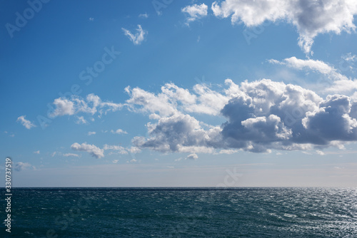 White clouds over a choppy sea in a sunny day © Dmitriy D