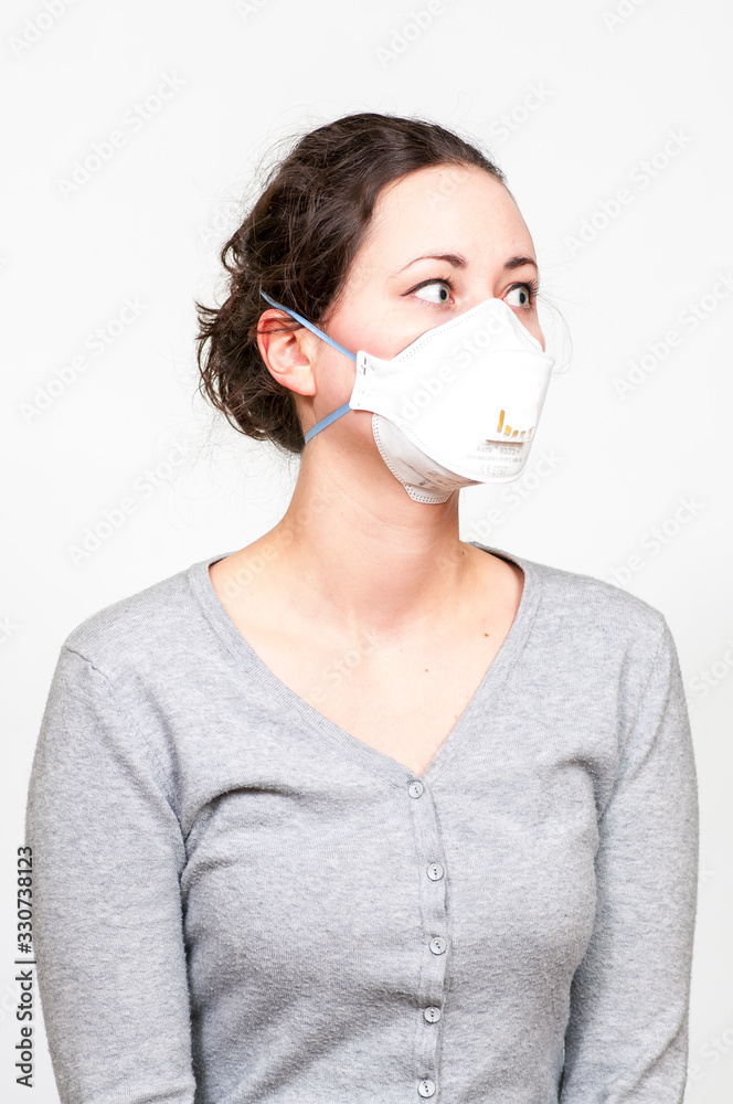 caucasian brunette woman in protective medical mask on face protection for spreading of disease virus SARS-CoV-2, Coronavirus, COVID-19. white background caucasian brunette woman in protective medical mask on face protection for spreading of disease virus SARS-CoV-2, Coronavirus, COVID-19. white background