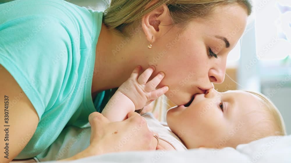 Happy mother and her baby. Mother kissing happy baby. Maternity concept Happy mother and her baby. Mother kissing happy baby. Maternity concept