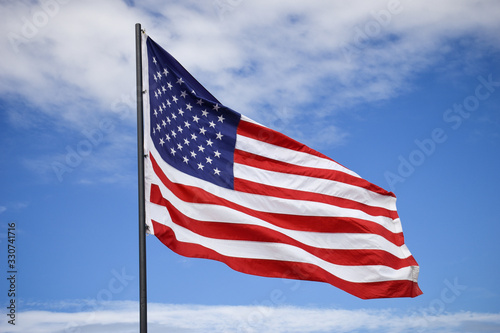 American flag on a nice summer day, symbol of Independence Day, July 4th, against background of dramatic blue sky
