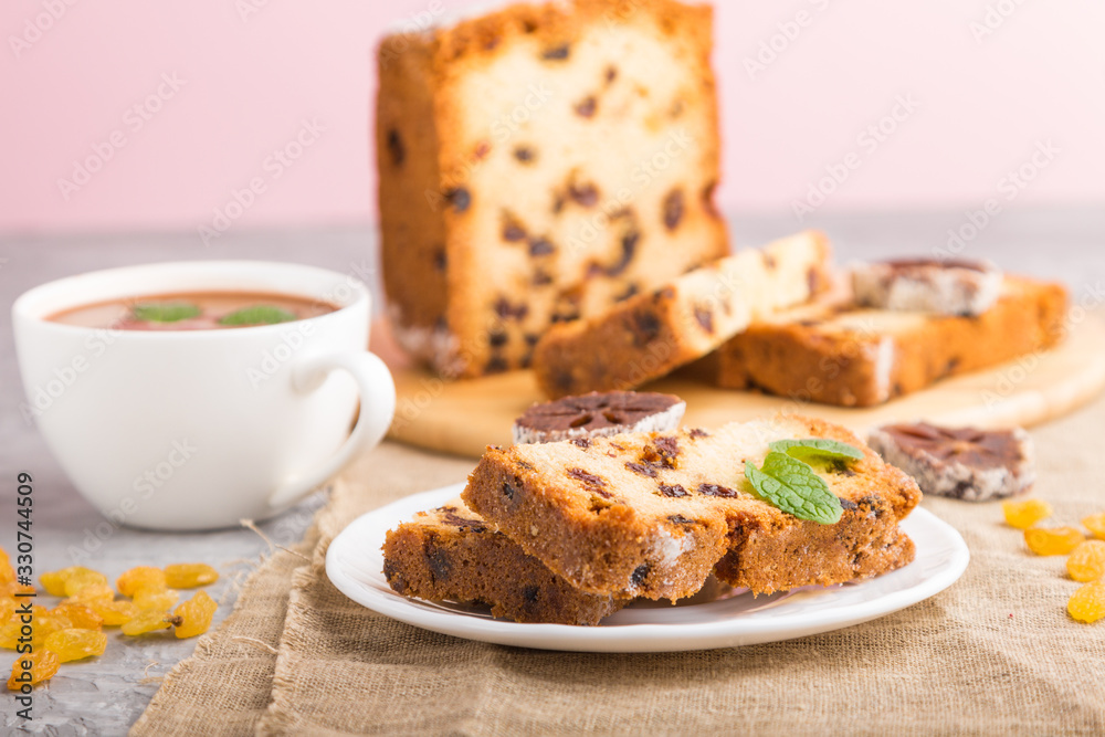 Homemade cake with raisins, dried persimmon and a cup of hot chocolate on a gray concrete background. side view, selective focus. Homemade cake with raisins, dried persimmon and a cup of hot chocolate on a gray concrete background. side view, selective focus.