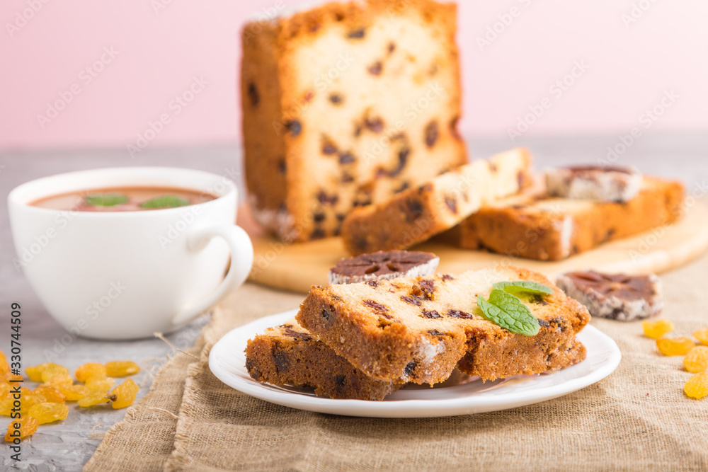 Homemade cake with raisins, dried persimmon and a cup of hot chocolate on a gray concrete background. side view, selective focus.