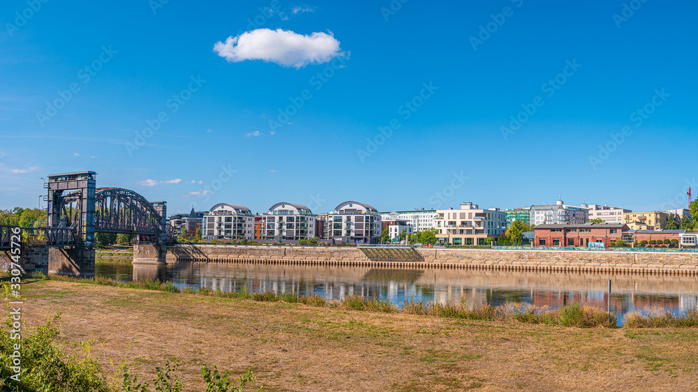 Cityscape of new buildings and old metal railway bridge in downtown of Magdeburg, Elbe riverbank, Germany