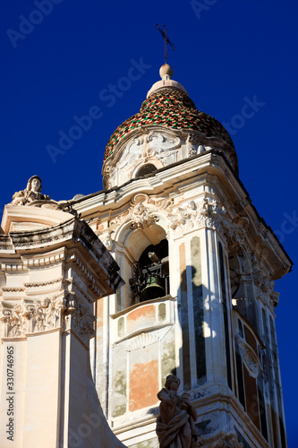 Laigueglia (SV), Italy - February 15, 2017: The bell tower and the church in Laigueglia village, Riviera dei Fiori, Savona, Liguria, Italy. photo