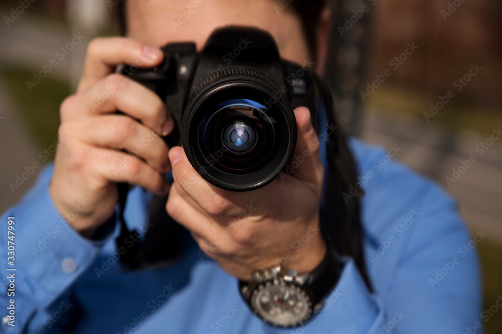 Photographer photographing outdoors. Shooting in urban city environment
