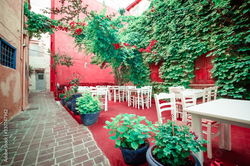 Fototapeta Naklejka Na Ścianę i Meble -  Cafe and restaurants at amazing narrow streets of popular destination on Paros island. Greece. Traditional architecture and colors of mediterranean city