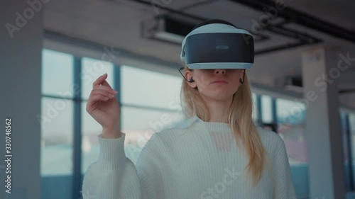 Close up woman using making gestures swipe when wearing virtual reality goggles empty building reaching technology looking entertainment gadget device tech game innovation portrait photo