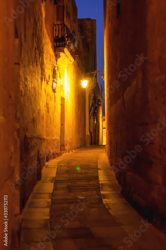 Narrow streets of Mdina  ancient capital of Malta. Night view on illuminated buildings and wall decorations of ancient town.